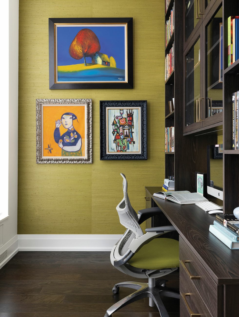 To maximize the impact of the backdrop, designer Kelly Perry deliberately made sure not to match the “pea-soup green” grass cloth wall covering with colors from a trio of paintings, two from Vietnam and one (the smallest) from Cambodia.